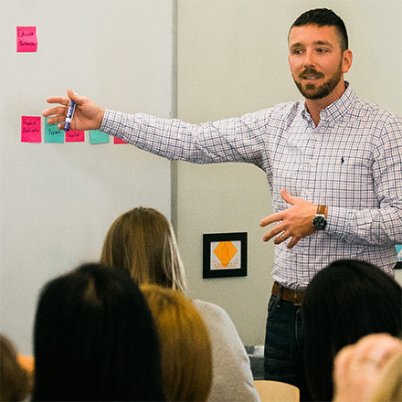 Eric Knudtson facilitating the Concept Mapping Together workshop, pointing to concept Post-its on a whiteboard